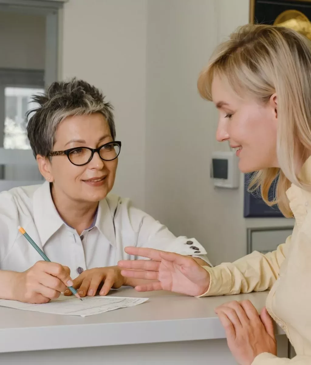 A clinician talking with a patient across a desk