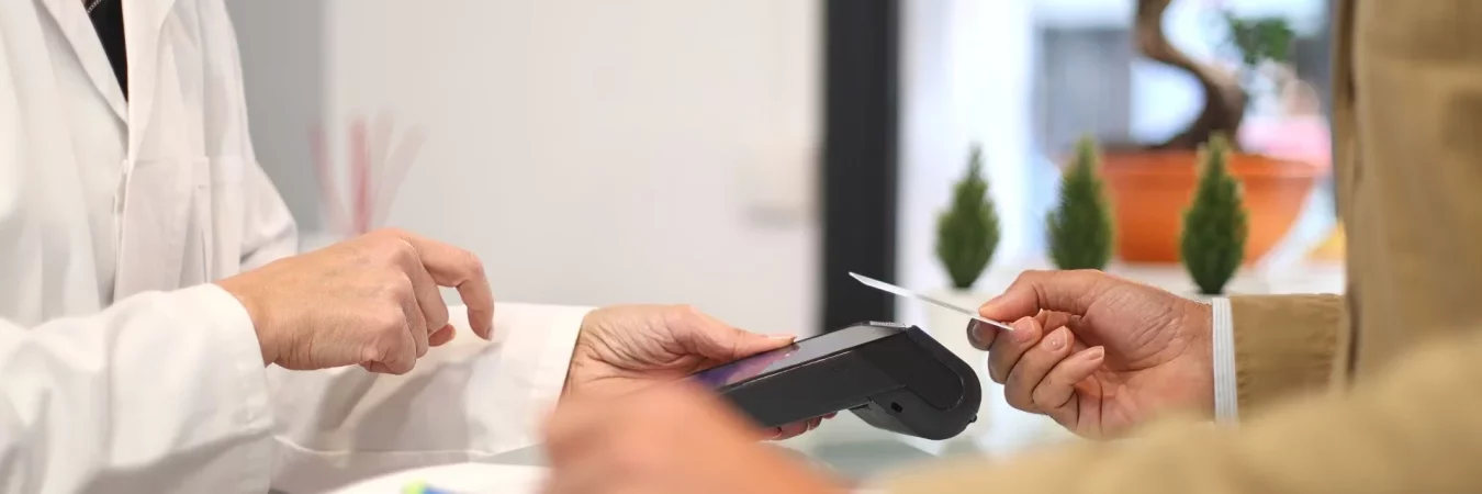 A patient paying by card at the reception desk