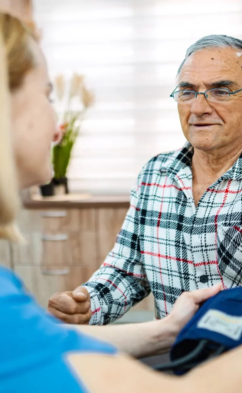 A nurse taking a senior patient’s blood pressure