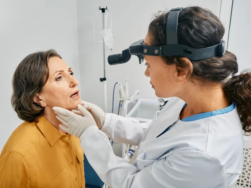 A doctor examining a patient’s throat